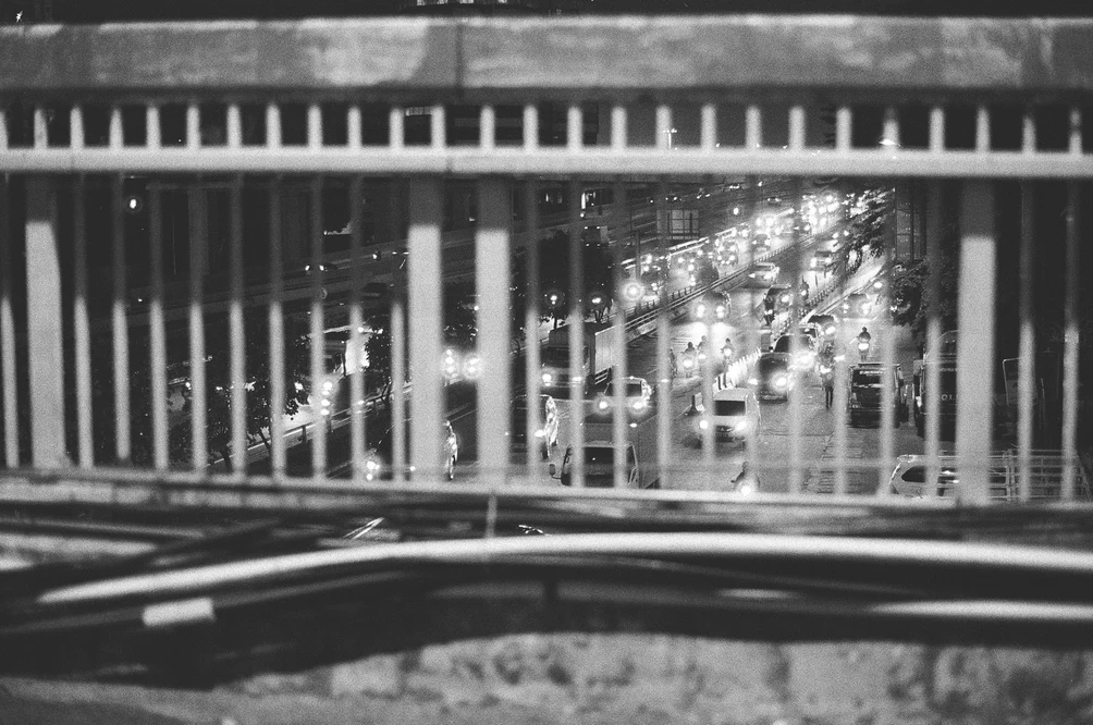 Night Traffic Through Overpass Bars. Shot with Olympus OM-1, Olympus Zuiko 50mm f/1.8, Kentmere 400 film